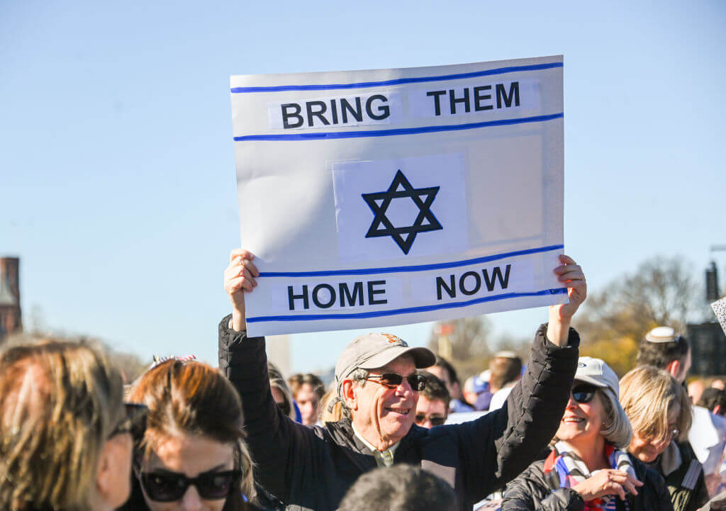 A person holds a sign reading "Bring them home now" during the March For Israel on the National Mall Nov. 14.