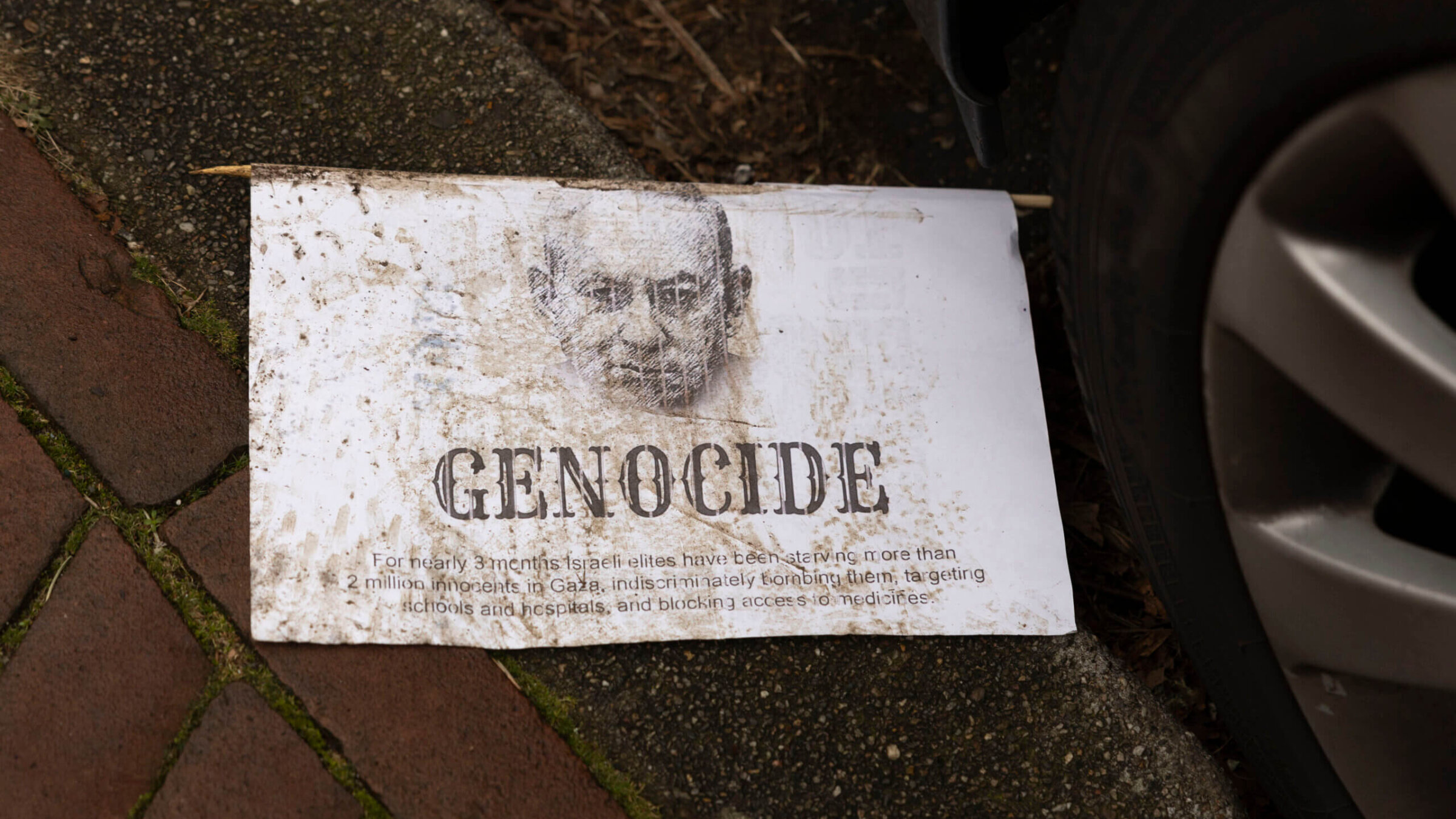 A leaflet with a drawing of Israeli Prime Minister Benjamin Netanyahu and the text 'genocide' lies on the curbside in front of the International Court of Justice on January 12 in The Hague, Netherlands.