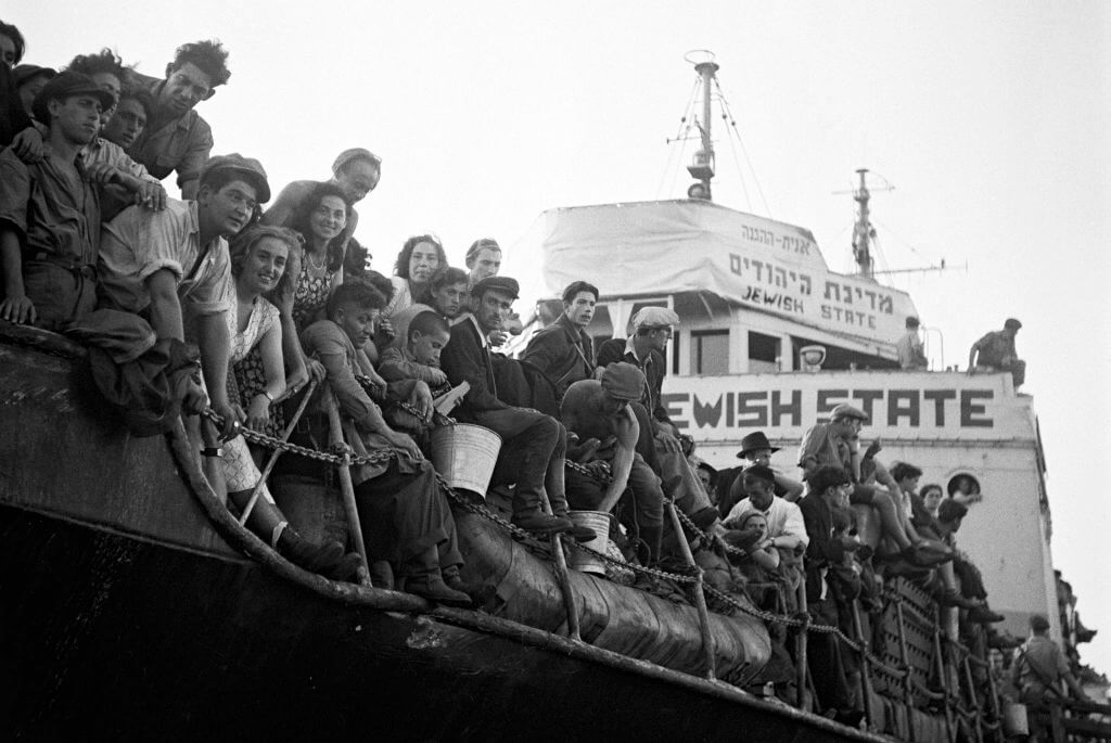 Jewish migrants aboard a Haganah ship in the port of Haifa, 1947. Carner's novel focuses on a child Holocaust survivor brought to Israel by Youth Aliyah, a branch of the Zionist movement. 
