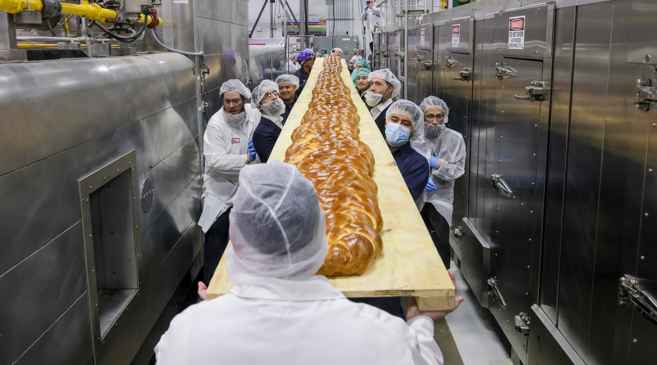 The 35 foot long challah was baked in a tunnel oven at David’s Cookies in New Jersey. It was then loaded onto a wooden plank and transported to the Upper West Side where it was unveiled at a day school’s Shabbat assembly. (JFNA/Vladimir Kolesnikov)