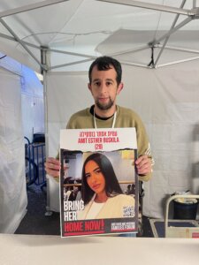 Tal Schechter volunteers at Hostage Square handing out posters of hostages as a way to keep up pressure for their release. Among those in the posters is his best friend, Amit Buskila.
