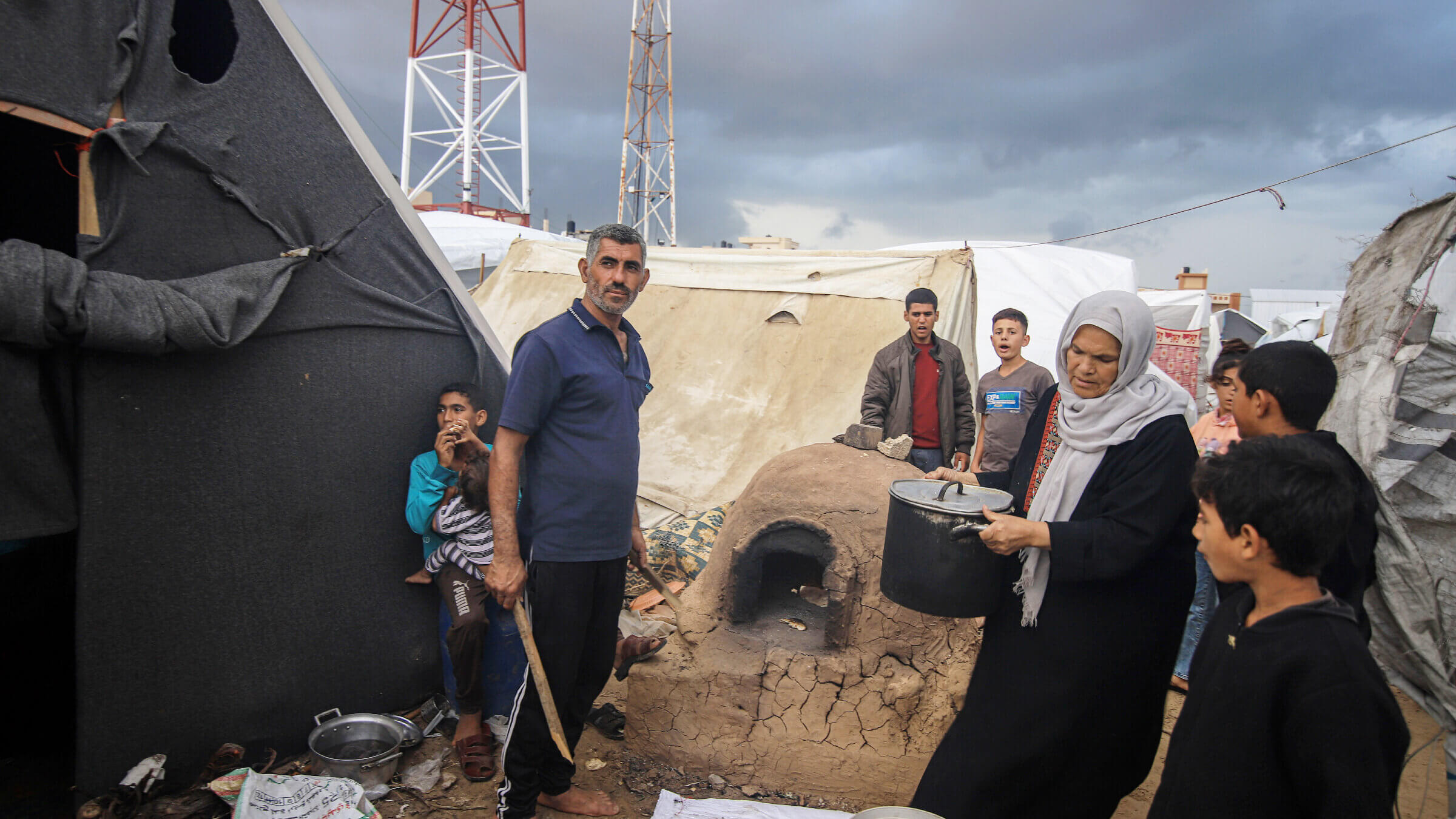 Displaced Palestinians  prepare food beside temporary shelters at a camp operated by the United Nations Relief and Works Agency in Khan Younis, Gaza, on Nov. 19, 2023