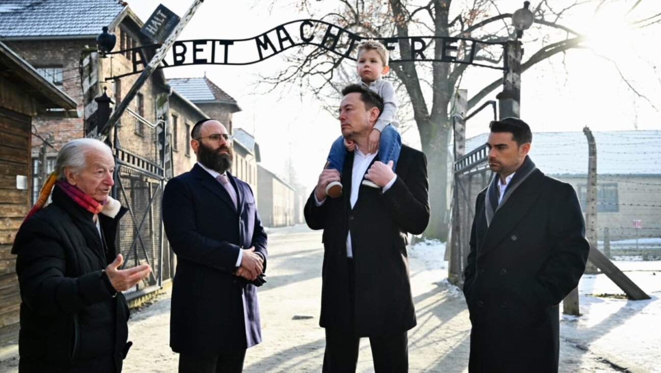 Holocaust survivor Gidon Lev, European Jewish Association Chairman Rabbi Menachem Margolin, Elon Musk with his son, and Ben Shapiro stand together at the entrance of Auschwitz, Jan. 22, 2024. (Courtesy EJA)