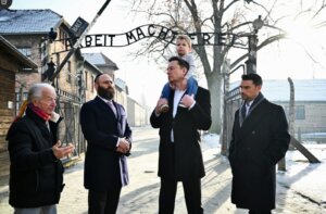 Holocaust survivor Gidon Lev, European Jewish Association Chairman Rabbi Menachem Margolin, Elon Musk with his son, and Ben Shapiro at the entrance of Auschwitz, Jan. 22, 2024.