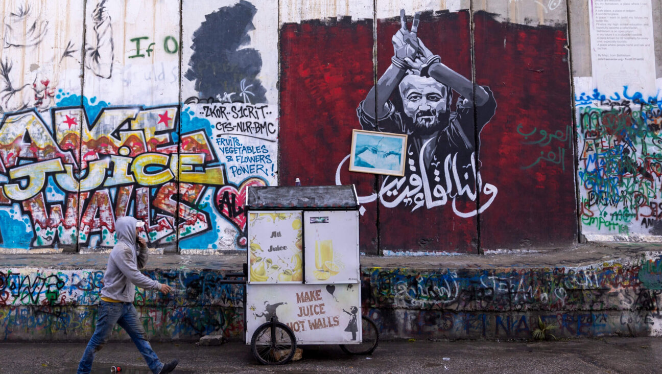A Palestinian man pass the graffiti showing Marwan Barghouti, a Palestinian imprisoned politician on December 24, 2023 in Bethlehem, West Bank. Last month, Christian Palestinian leaders here called off public Christmas celebrations, citing the effects of the ongoing war in Gaza. 