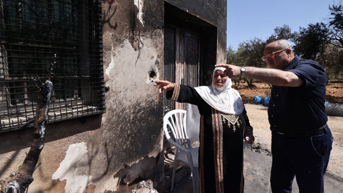 Arab-Israeli Knesset member Ahmed Tibi speaks with a house owner at the site of an attack by Israeli settlers on the village of Turmus Ayya near the West Bank city of Ramallah, June 24, 2023. (Ahmad Gharabli/AFP via Getty Images)