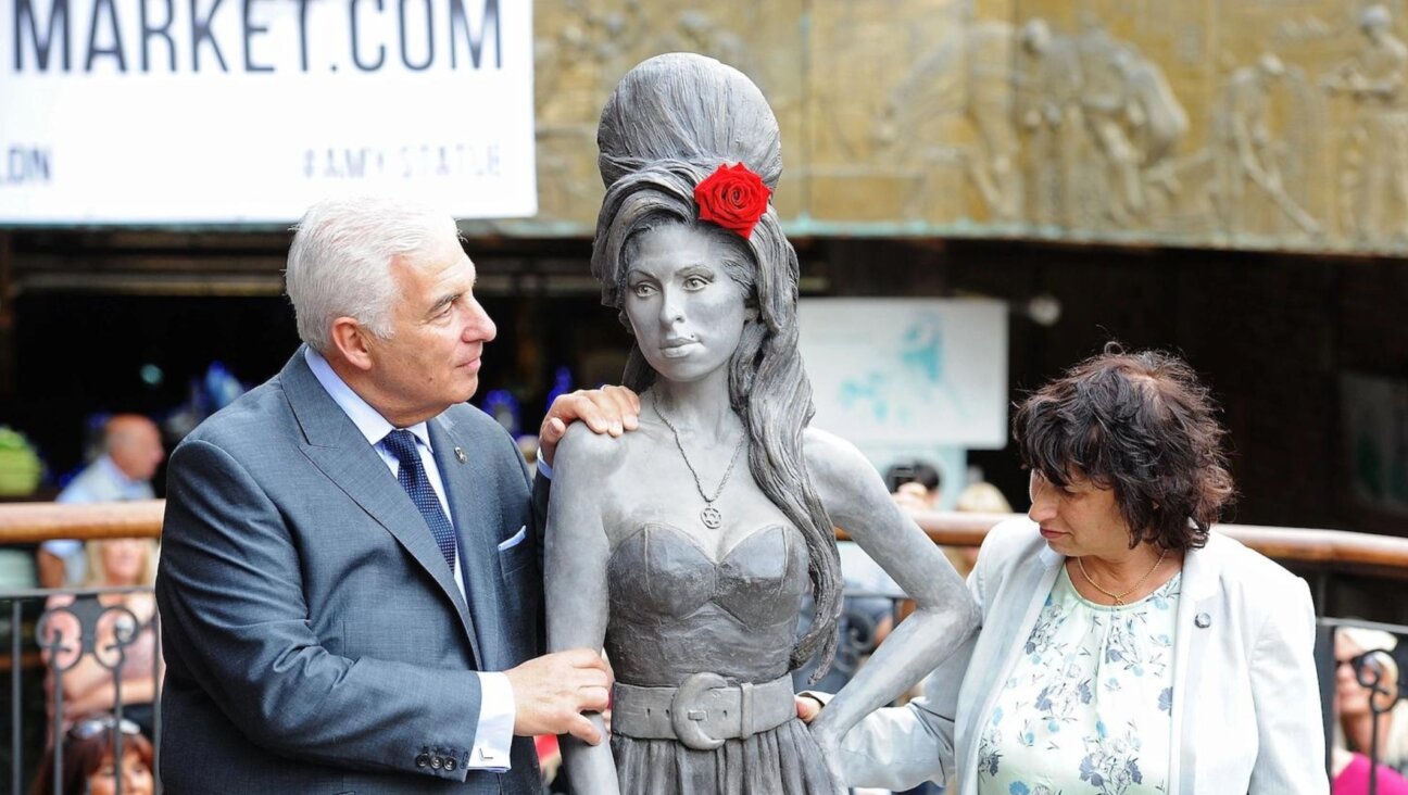 Mitch Winehouse and Janis Winehouse pose as a statue of the late Amy Winehouse is unveiled in Camden Town on Sept. 14, 2014 in London. (Dave Hogan/Getty Images)