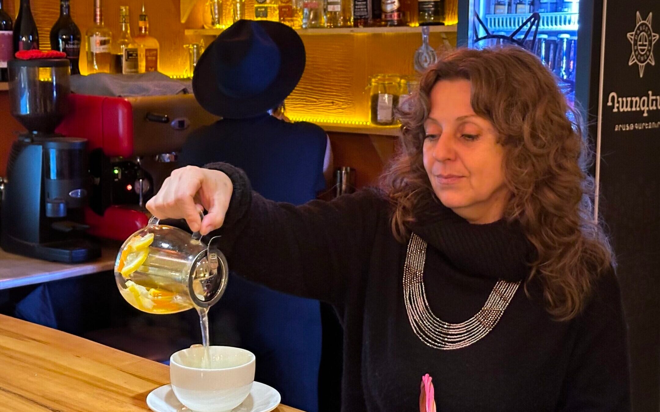Julia Kislev, a Crimean Jew who’s been living in Armenia since 2016, pours a cup of tea at Mama Jan, the café she owns in Yerevan. Mama Jan has become the unofficial gathering place for Russian Jews who have settled here since Russia invaded Ukraine two years ago. (Larry Luxner)