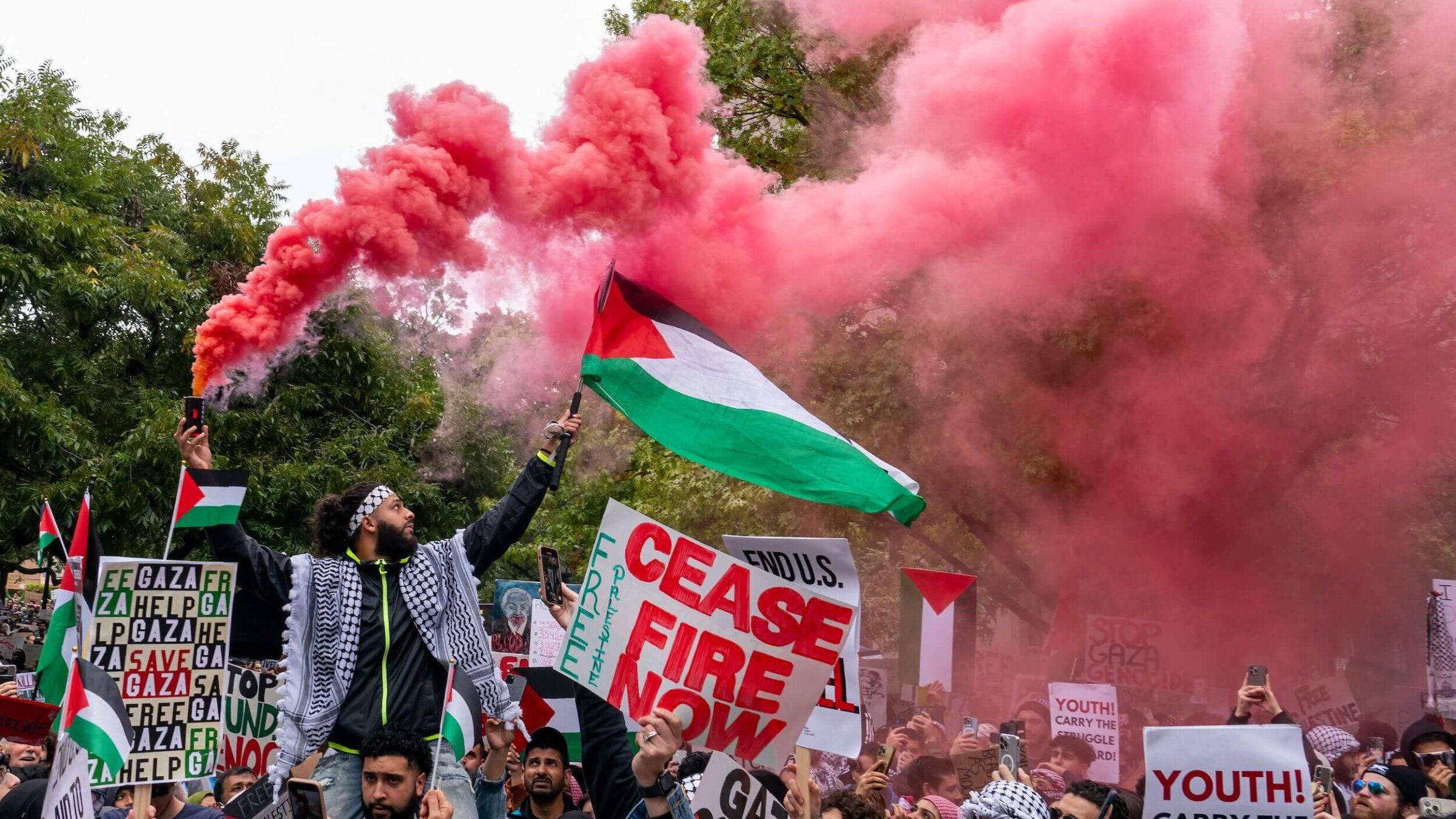 A protester holds a flare and a Palestinian flag during a rally in support of Palestinians at the Texas State Capitol in Austin, Texas, on November 12, 2023. 