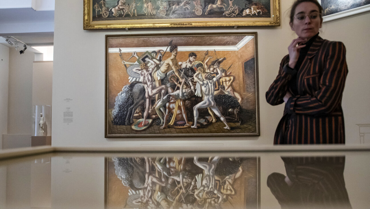 An exhibition staff member stands near artworks <i>Chariot Race</i> (<i>top</i>) and <i>The School of Gladiators: The Combat</i> by Italian painter Giorgio de Chirico at the press preview of the <i>Dans l'appartement de Léonce Rosenberg - De Chirico, Ernst, Léger, Picabia</i> exhibition at the Picasso Museum in Paris.