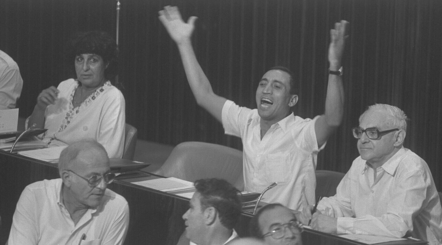 Israeli lawmaker Charlie Biton raises his arms in one of his spirited interjections during parliamentary debate in Jerusalem, Oct. 10, 1983.