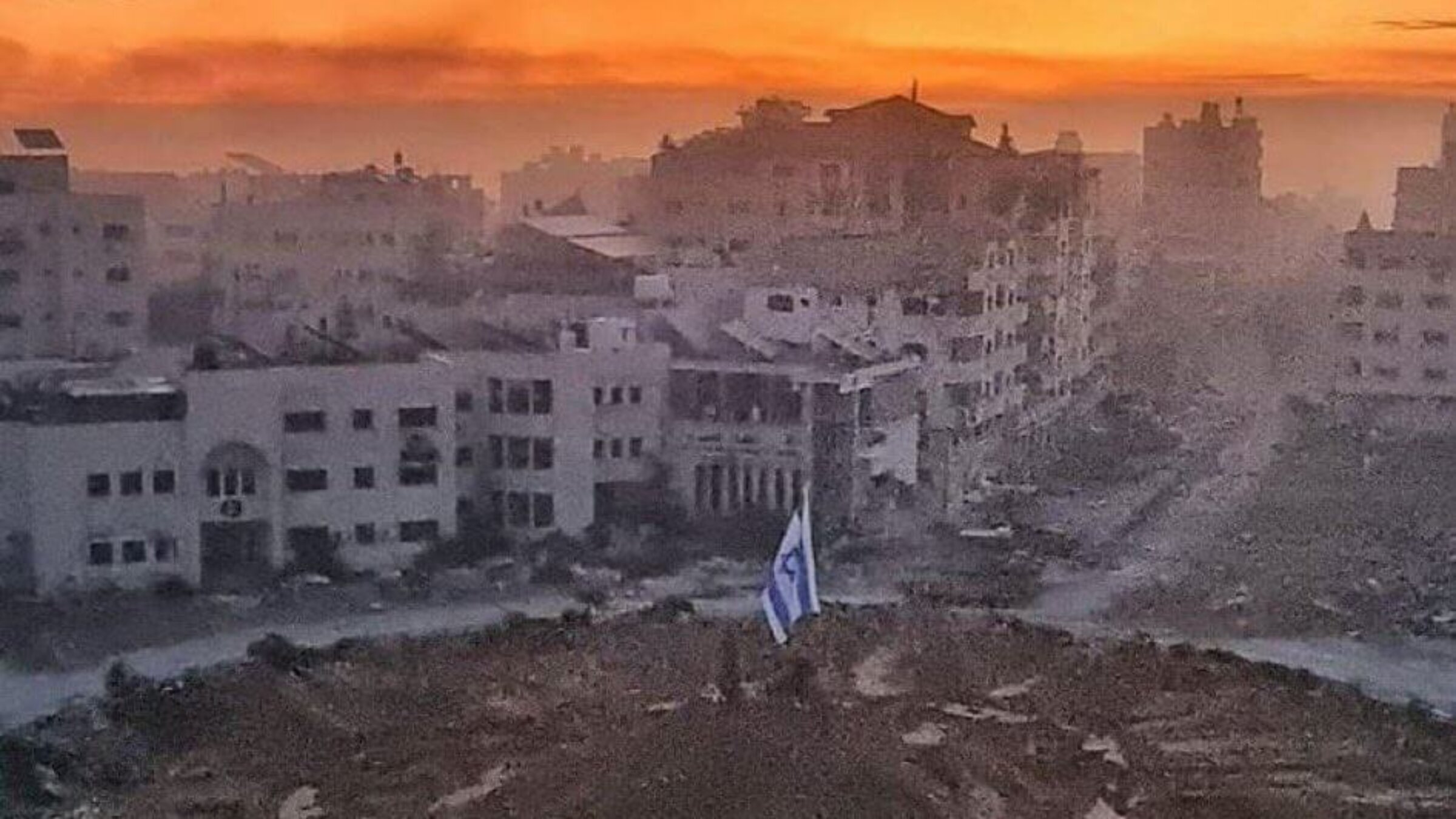 An Israeli flag is planted amid a central square in the ruins of Gaza City.