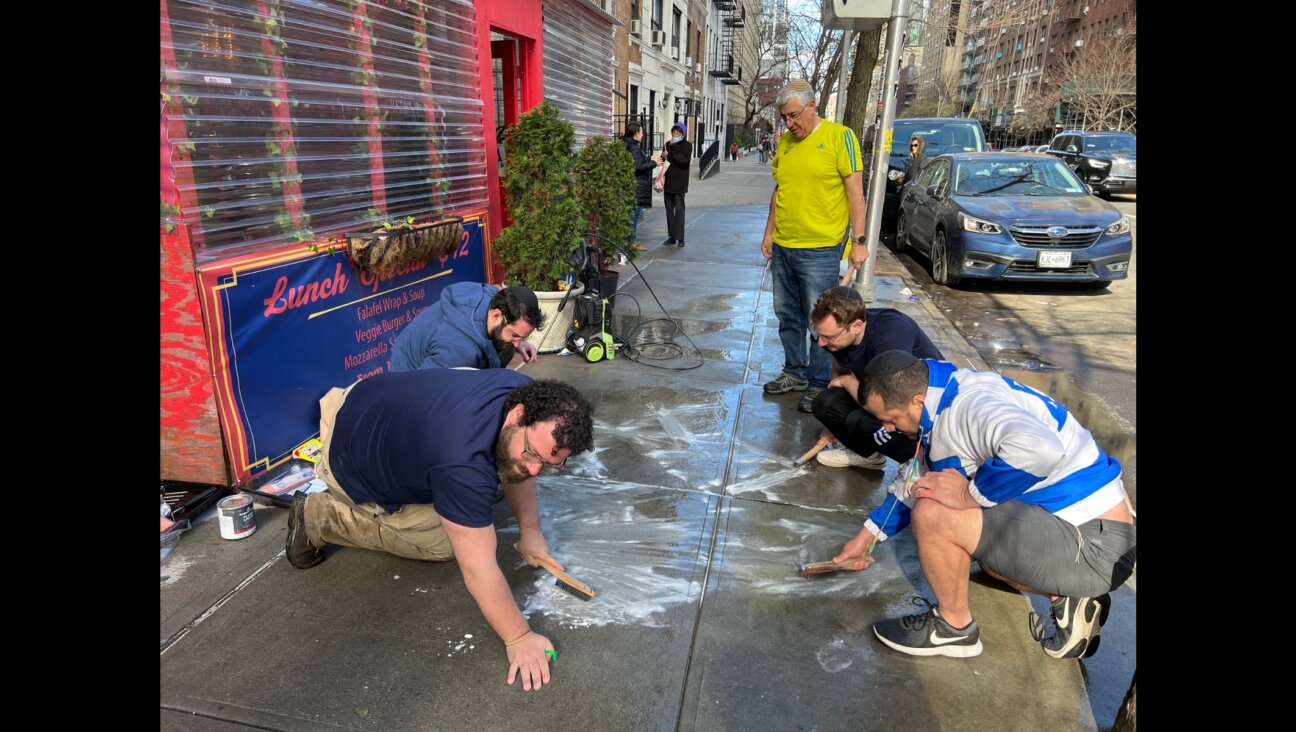On their hands and knees, a group of Jewish volunteers scrub pro-Palestinian graffiti from the sidewalk outside of Effy’s Café, a kosher restaurant on the Upper West Side. (Jackie Hajdenberg)