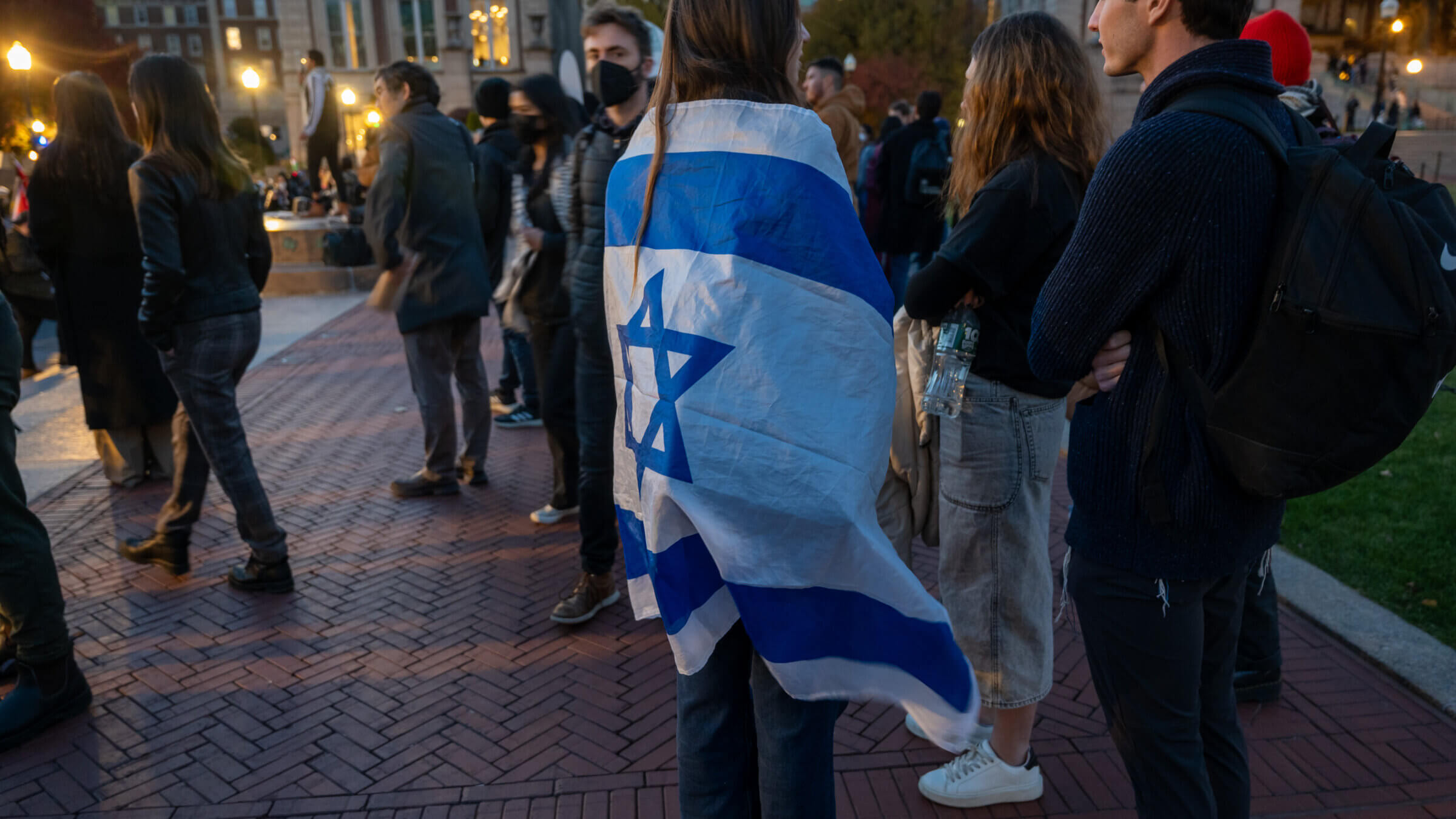 A student at Columbia University wraps herself in an Israeli flag during a fall protest.