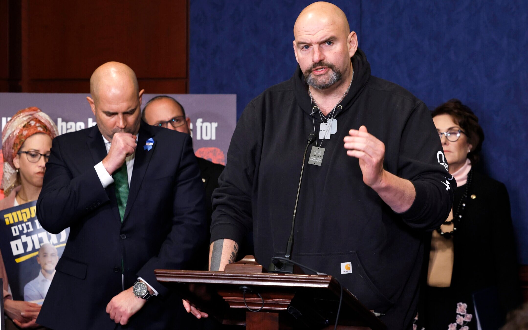 Wearing “Bring Them Home” dog tags, Sen. John Fetterman (D-PA) speaks during a news conference at the U.S. Capitol after hosting families of Israeli hostages in Gaza, Feb. 7, 2024. (Anna Moneymaker/Getty Images)