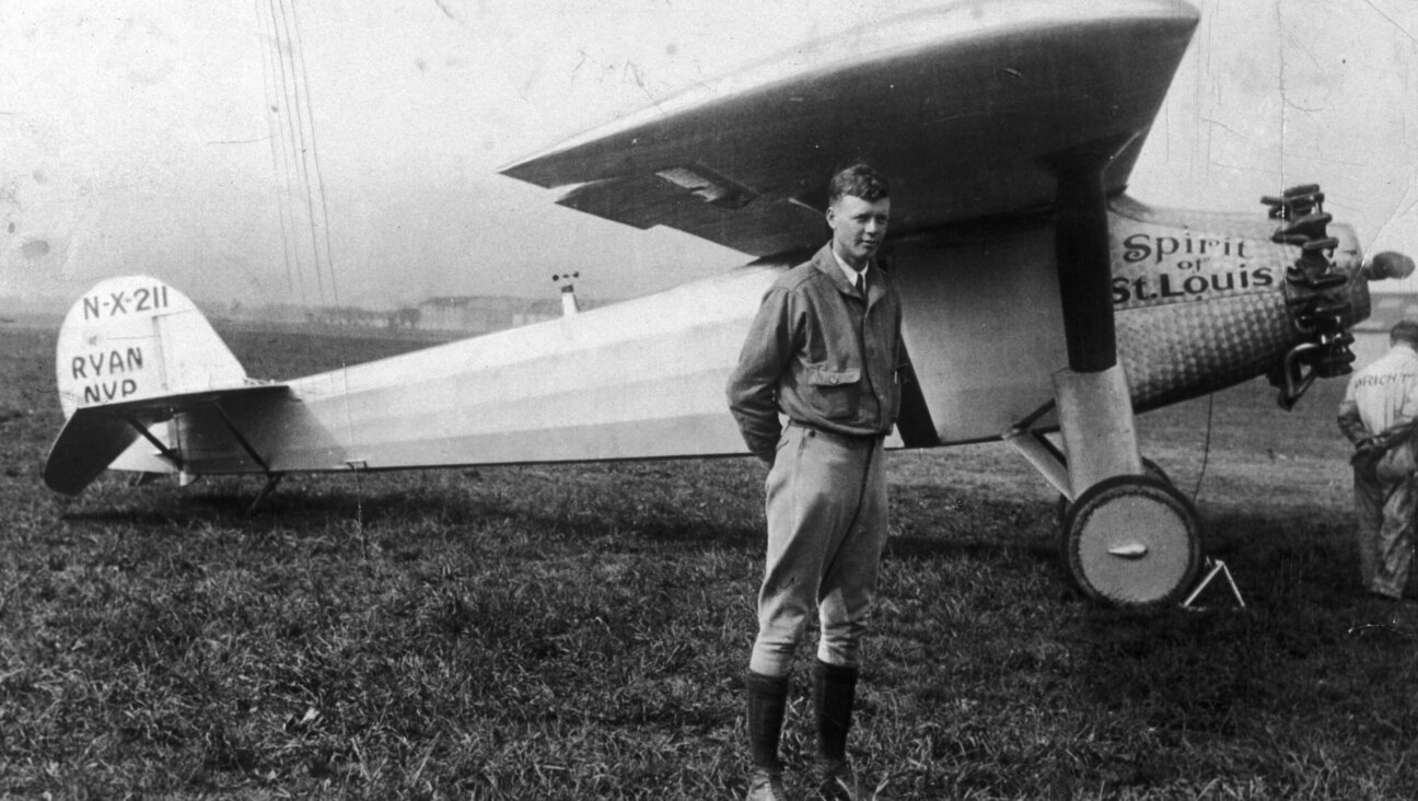 Charles Lindbergh posing under the wing of his Ryan monoplane, named the Spirit of St. Louis.  