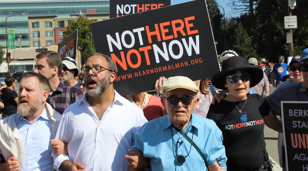 Holocaust survivor Ben Stern (blue shirt) leads 200 marchers in the “Bay Area Rally Against Hate” in Berkeley in August 2017. He is linking arms with his daughter Charlene Stern and Rabbi Menachem Creditor; Rabbi Yonatan Cohen of Congregation Beth Israel in Berkeley is at far left. (Rob Gloster/J.)