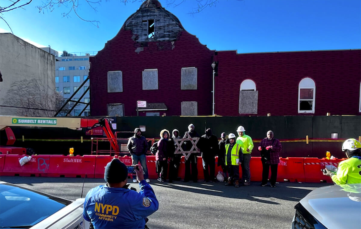 Members of Congregation B’nai Adath Kol Beth Yisrael in Brooklyn stand with the Star of David ornament removed from the building before its demolition.