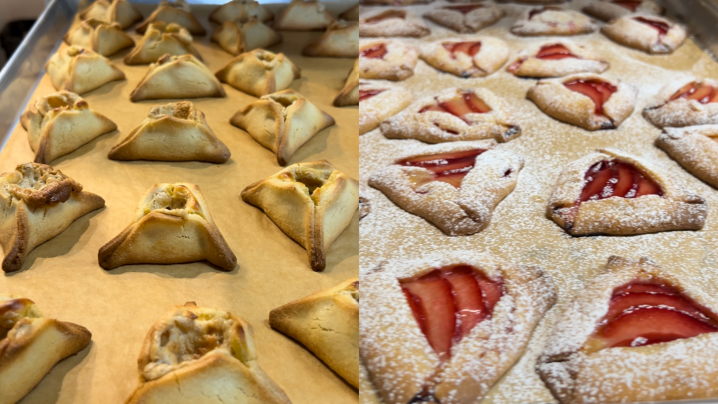 On the left, a tray full of triangular hamantaschen cookies with wide openings and creamy, tan-colored fillings that spill a little over the openings. On the right, triangular hamantaschen cookies that are more flat and have red slices of plum in the center and are covered with powdered sugar.