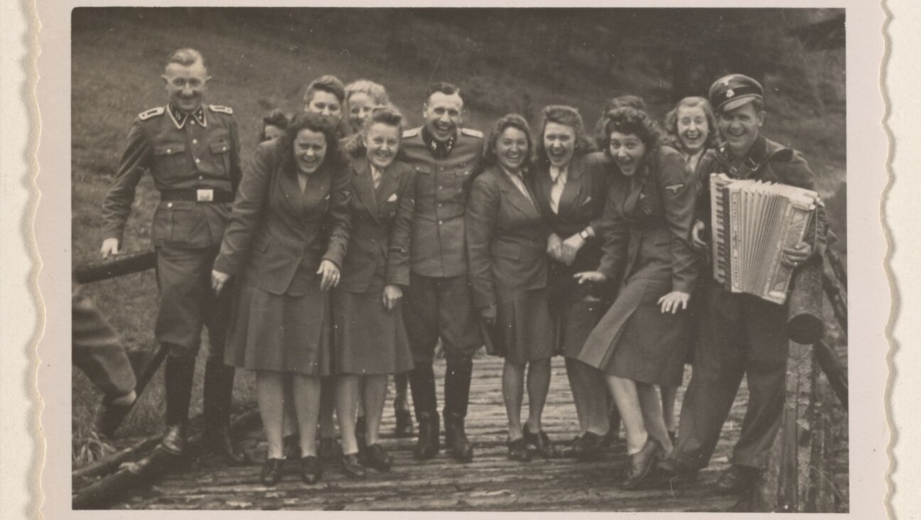 Women's auxiliaries and SS officers enjoy music not far from the barracks of Auschwitz-Birkenau.   