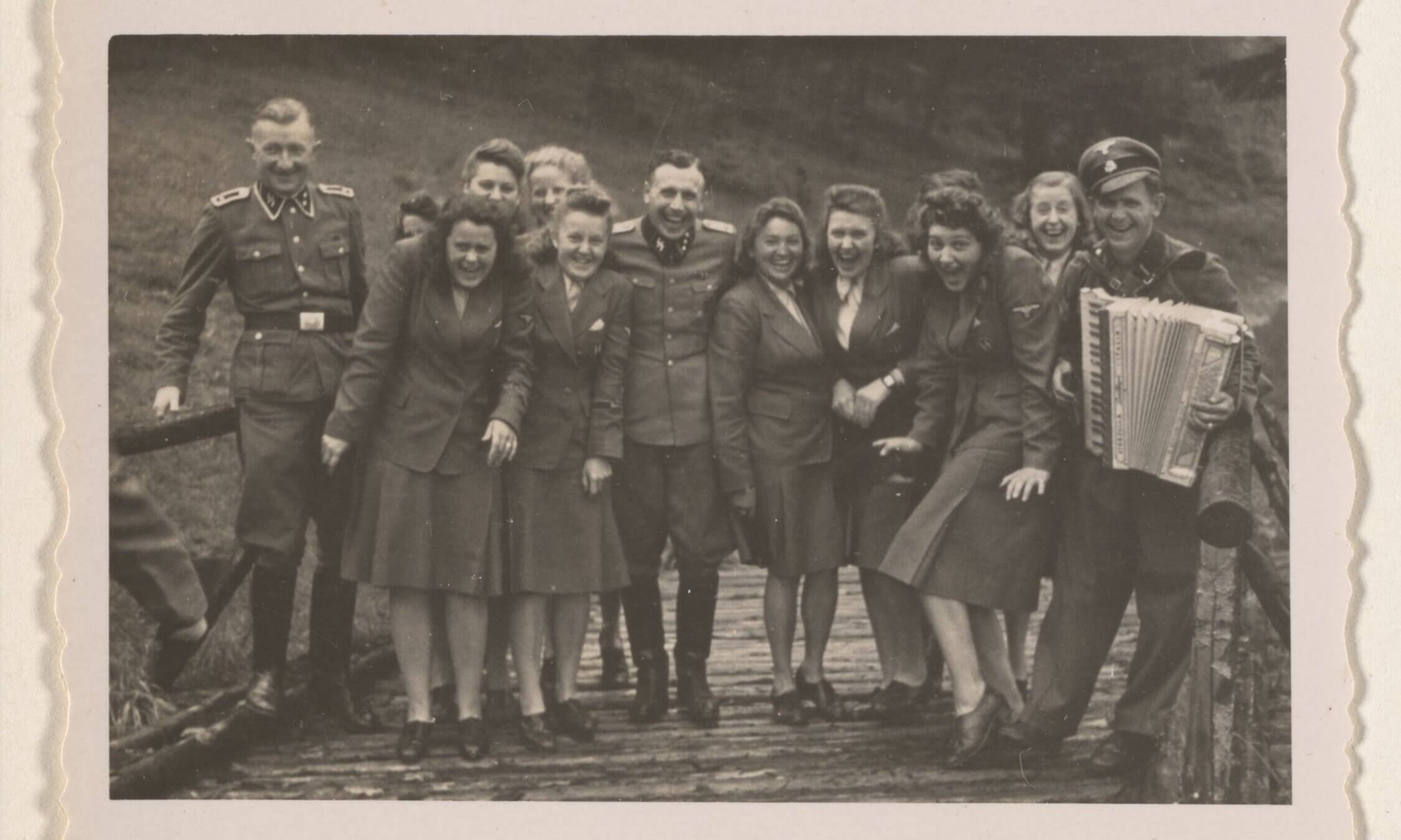 Women's auxiliaries and SS officers enjoy music not far from the barracks of Auschwitz-Birkenau.   