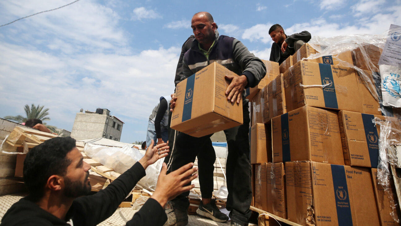 Palestinians distribute boxes of aid before the Eid al-Fitr holiday, which marks the end of the Muslim holy fasting month of Ramadan, amid the ongoing conflict between Israel and Hamas, in Deir Al-Balah, in the central Gaza Strip, on April 8, 2024. (Majdi Fathi/NurPhoto via Getty Images)