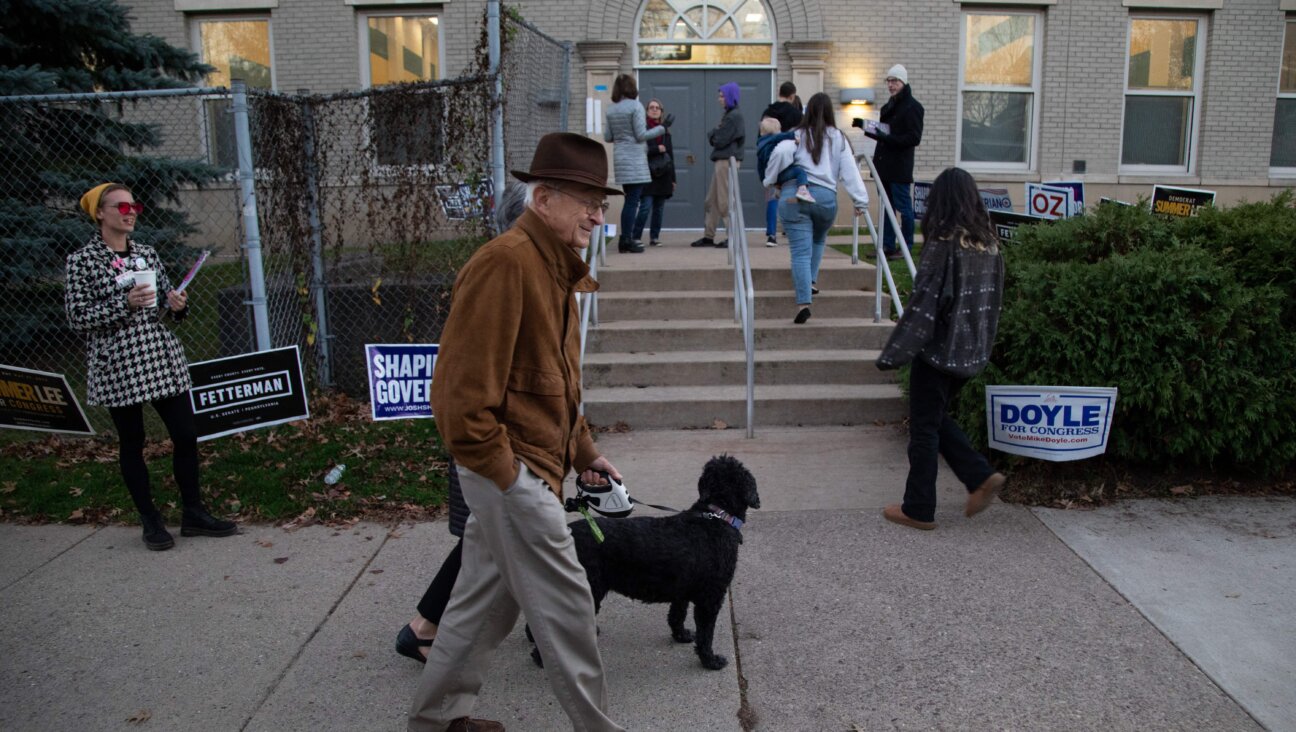 A couple walks their dog past a polling place in Pittsburgh two years ago. A new organization plans to score politicians on how friendly they are to the Jewish community in western Pennsylvania.