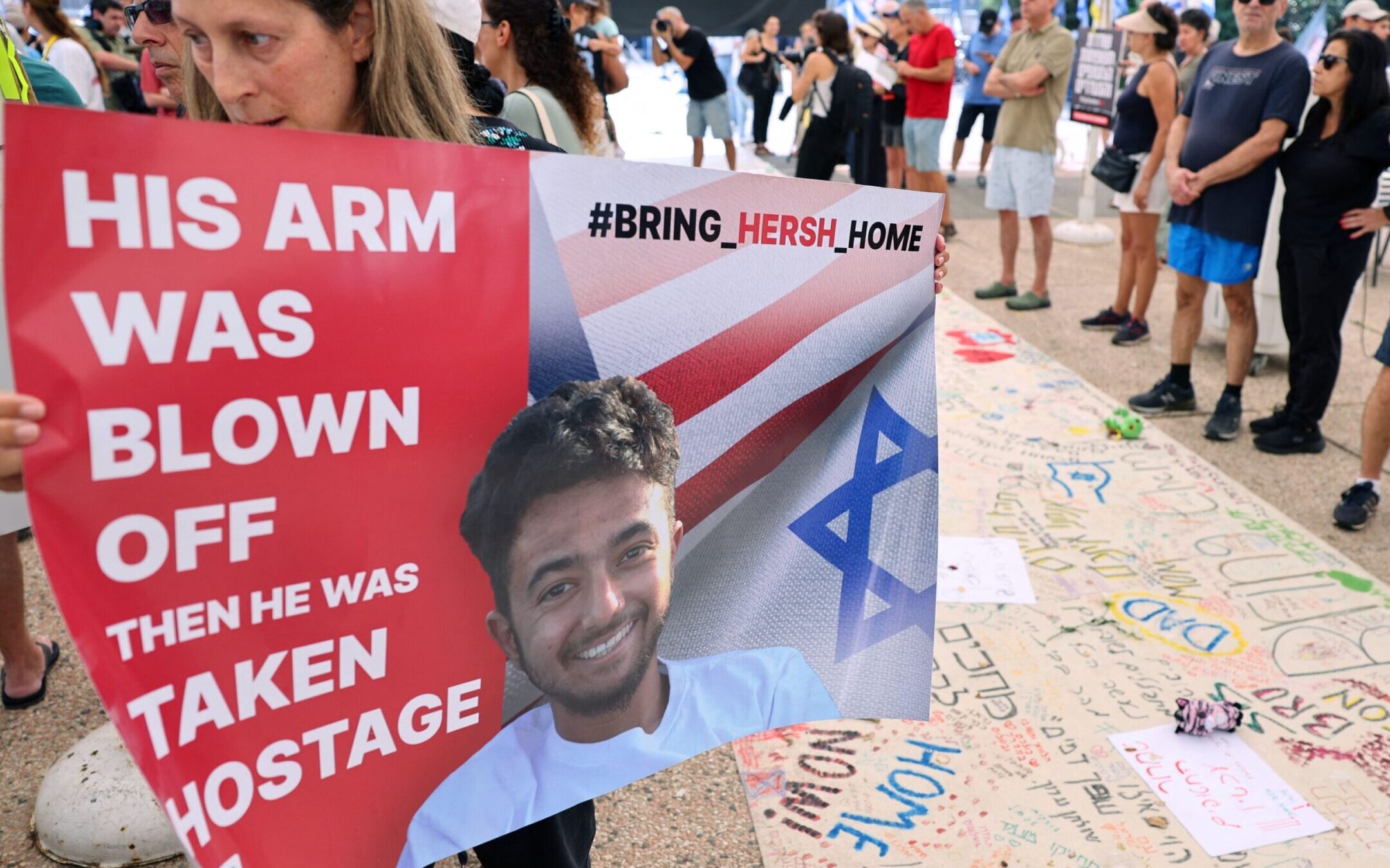 A protester holds a poster with a photo of 23-year-old U.S.-Israeli Hersh Goldberg-Polin as people gather with signs calling for the release of hostages held by Hamas since Oct. 7, during a rally in Tel Aviv, October 28, 2023. (Jack Guez/AFP via Getty Images)