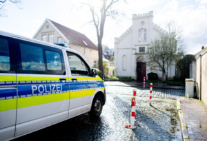 A police vehicle stands in front of the synagogue in the city center of Oldenburg, Germany, after an incendiary device was thrown at its door.