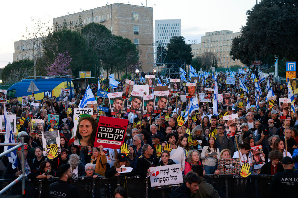 Relatives and supporters of Israeli hostages lift placards during a demonstration in front of the Israeli parliament in Jerusalem on April 7, 2024.