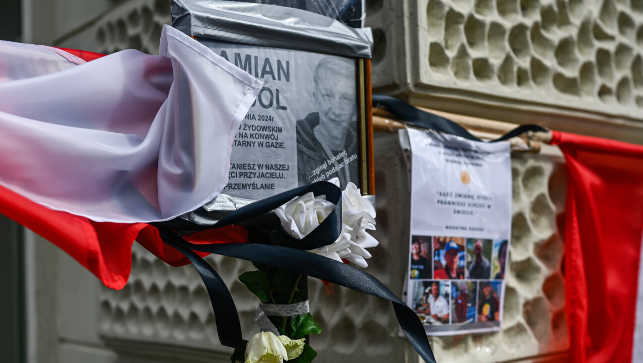 : A portrait of Damian Sobol hangs among Polish national flags, flowers and candles at a temporary memorial in front of a train station in Przemysl, Poland. Sobol was among the workers for World Central Kitchen who were killed in Gaza by an Israeli drone strike. 
