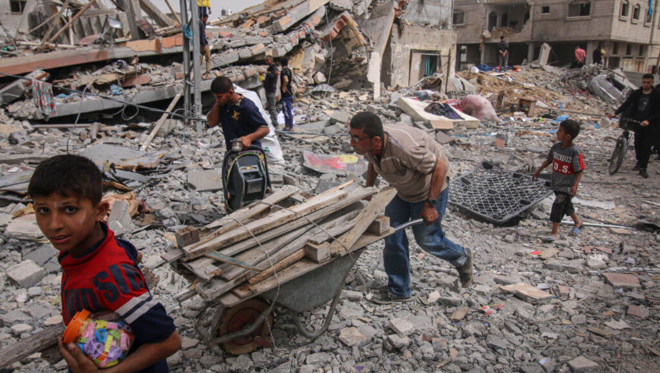 Palestinians recover items from rubble in Nuseirat camp, central Gaza Strip, on Thursday, April 18, 2024.