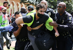 USC public safety officers detain a pro-Palestine demonstrator during clashes after officers attempted to take down an encampment in support of Gaza at the University of Southern California on April 24, 2024  