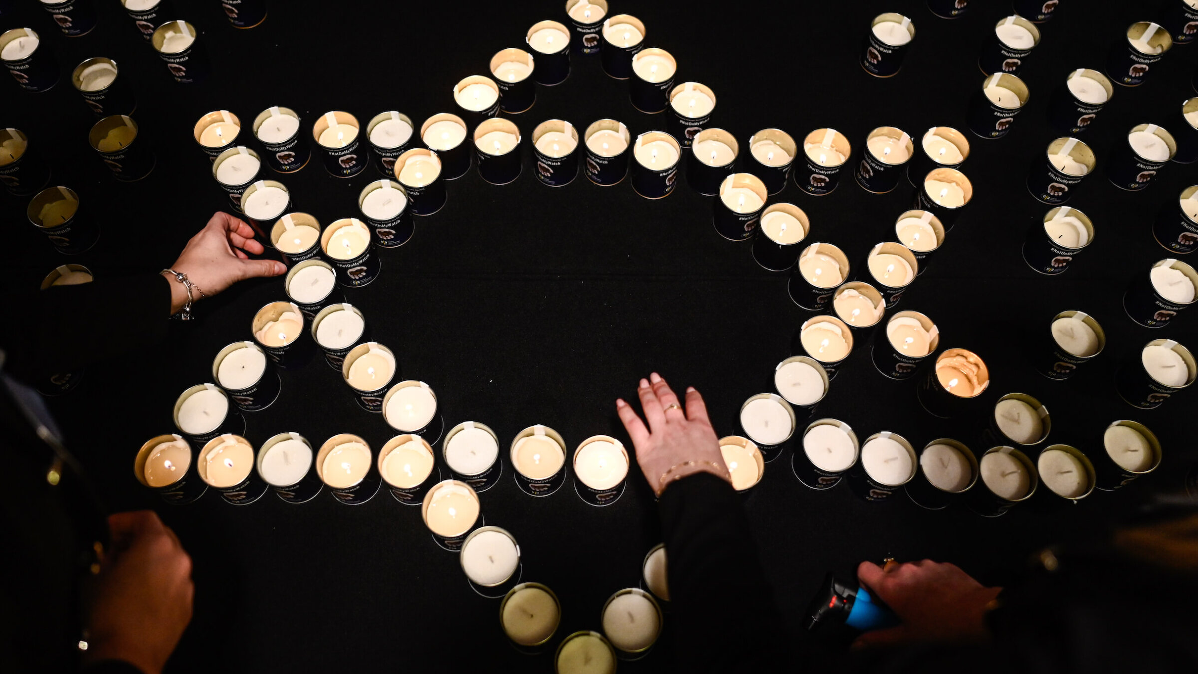Women light candles in the shape of a Star of David during a January symposium on fighting antisemitism in Krakow, Poland.