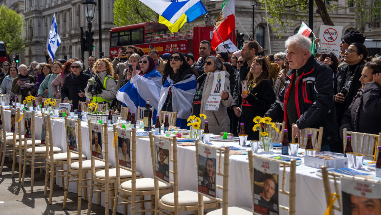 People gather around an empty Seder table in London featuring 133 chairs representing the Israeli hostages who remain in Gaza.