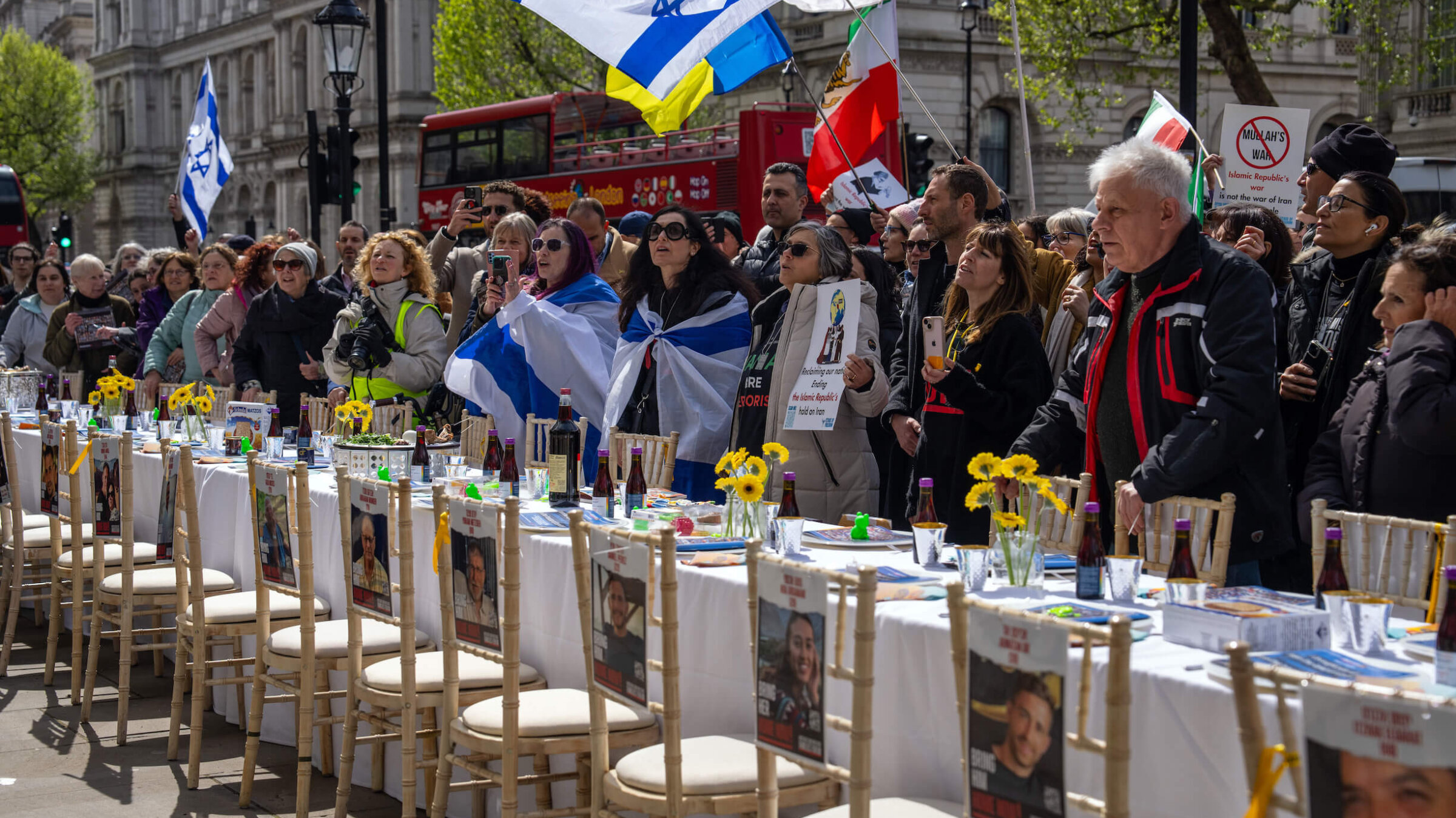 People gather around an empty Seder table in London featuring 133 chairs representing the Israeli hostages who remain in Gaza.