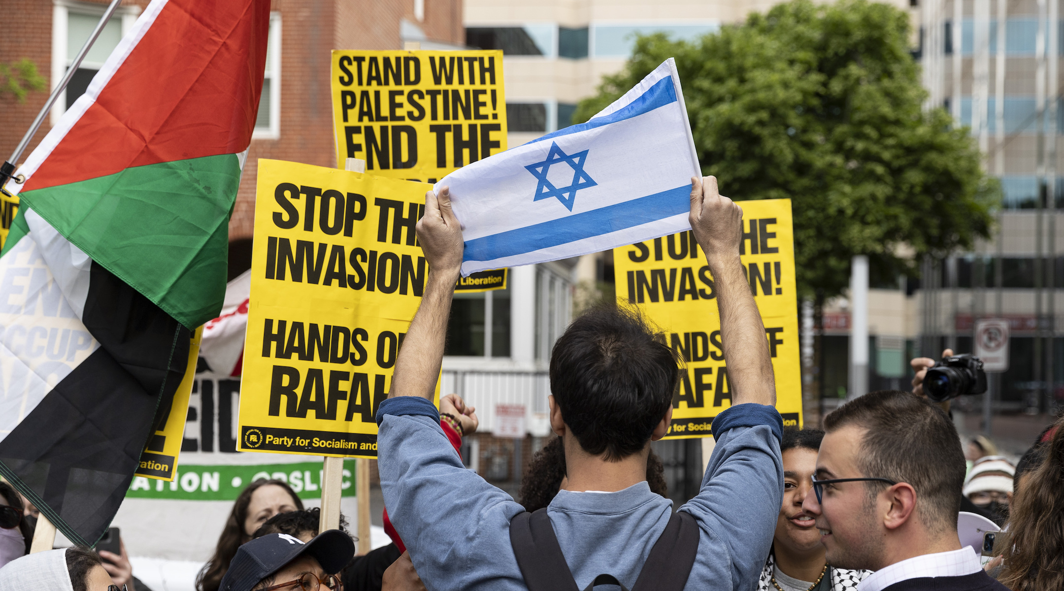A man holds an Israeli flag while counter-demonstrating against a pro-Palestinian protest at George Washington University in Washington, D.C., April 25, 2024.