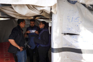 Palestinian journalist Hind Khoudary, right, and Anadolu Agency photographer Ali Jadallah speak with a colleague inside a tent at a makeshift camp for displaced people in front of the Al-Aqsa Martyrs Hospital in Deir al-Balah in the central Gaza Strip, after it was hit by Israel bombardment on March 31.