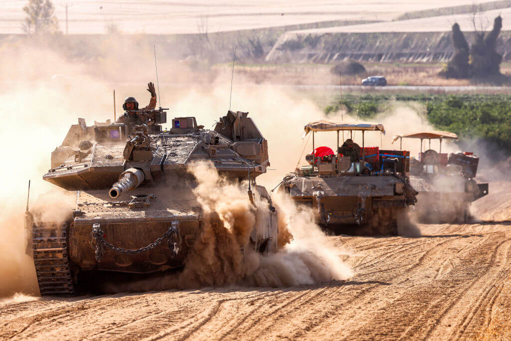 Israeli army tanks move near the border with the Gaza Strip at a location in southern Israel on May 13, 2024.