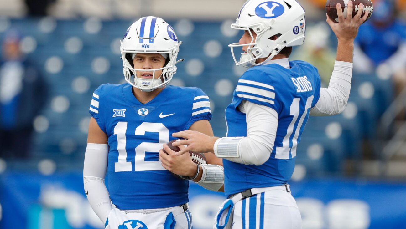 Jake Retzlaff, left, and Kedon Slovis of the Brigham Young Cougars talk during warmups before their game against the Oklahoma Sooners, Nov. 18, 2023. (Chris Gardner/Getty Images)