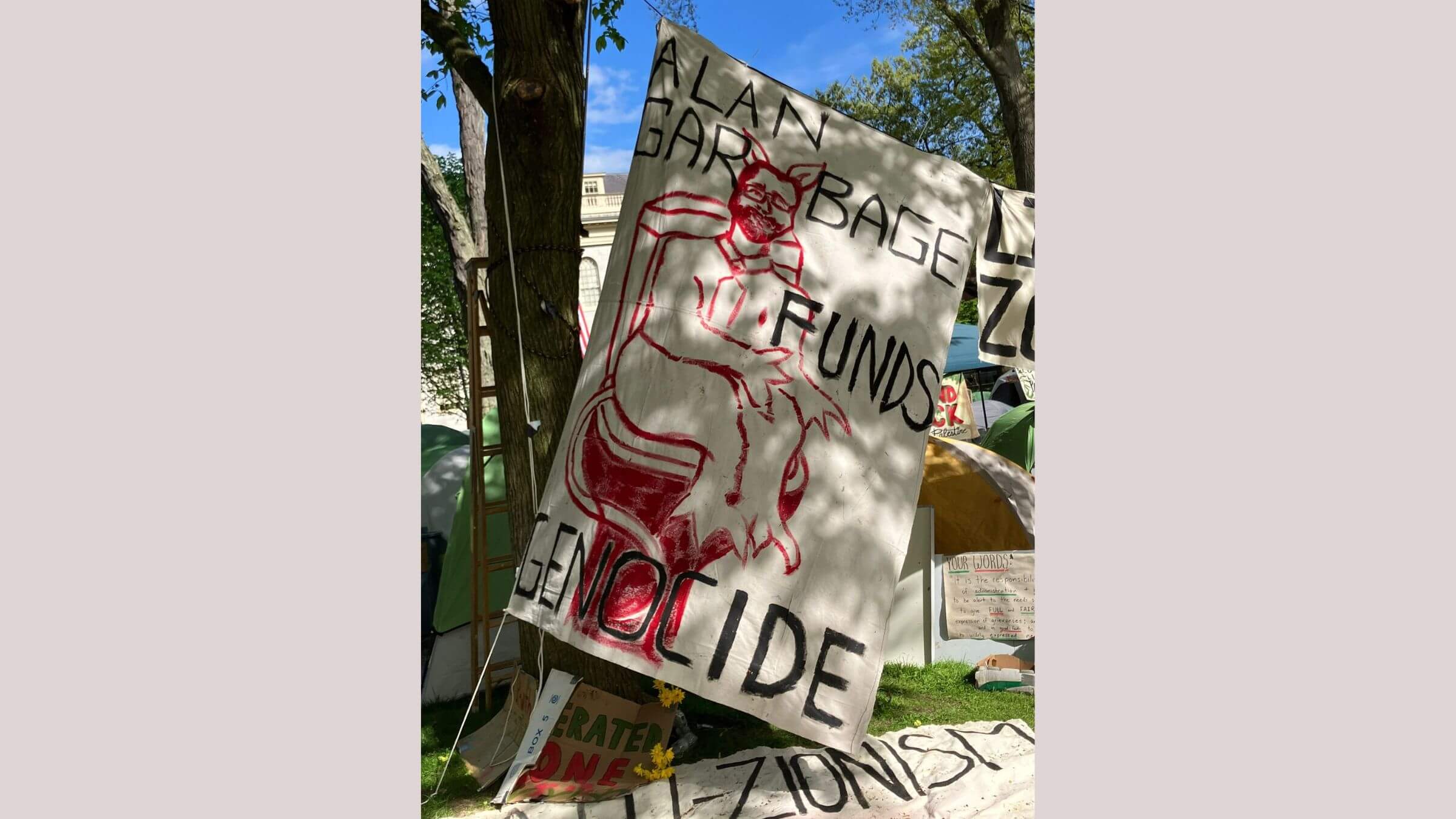 Critics say this sign at a pro-Palestinian encampment at Harvard was antisemitic because it depicts Harvard's Jewish president as a devil. 