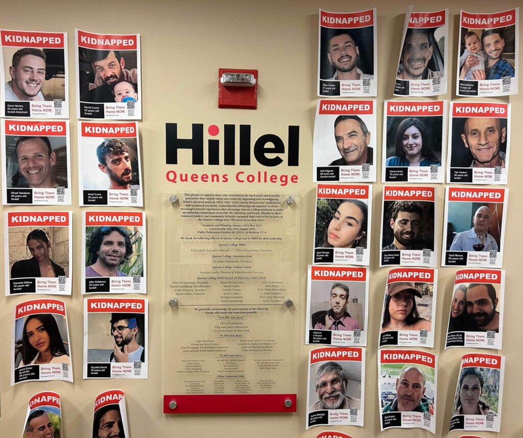 A sign that says "Hillel: Queens College" surrounded by posters with images of people's faces and the word "kidnapped" in all caps.