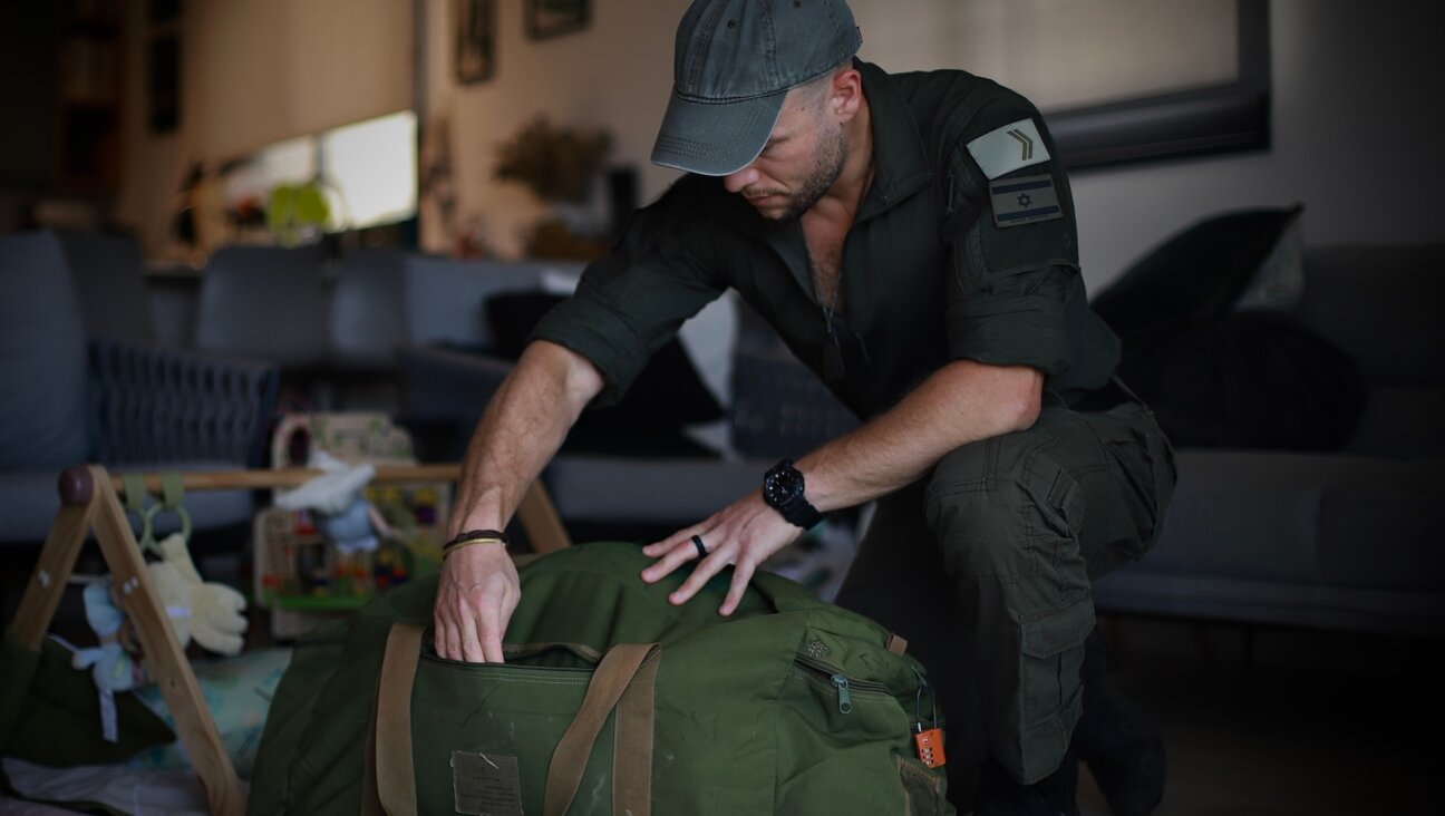 Micha Shtiebel, an IDF reservist of the Alexandroni Brigade, sorts through his army duffle bag containing equipment that he’s either bought himself or received from donors at his house in Ra’anana, Israel, May 26, 2024. (Yakov Binyamin)