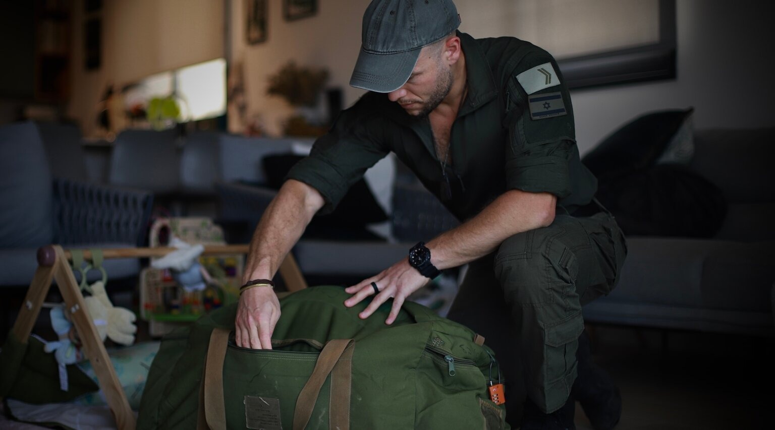 Micha Shtiebel, an IDF reservist, sorts through his duffel bag containing equipment that he’s either bought himself or received from donors. (Yakov Binyamin)