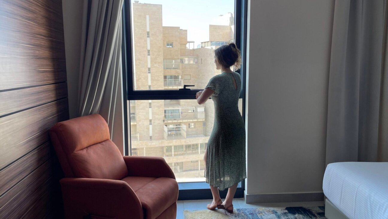 A woman looks out the window at the Yirmiyahu33 complex, home to Israel’s first hotel for women and couples who have experienced stillbirth. (Courtesy Yad Sarah)