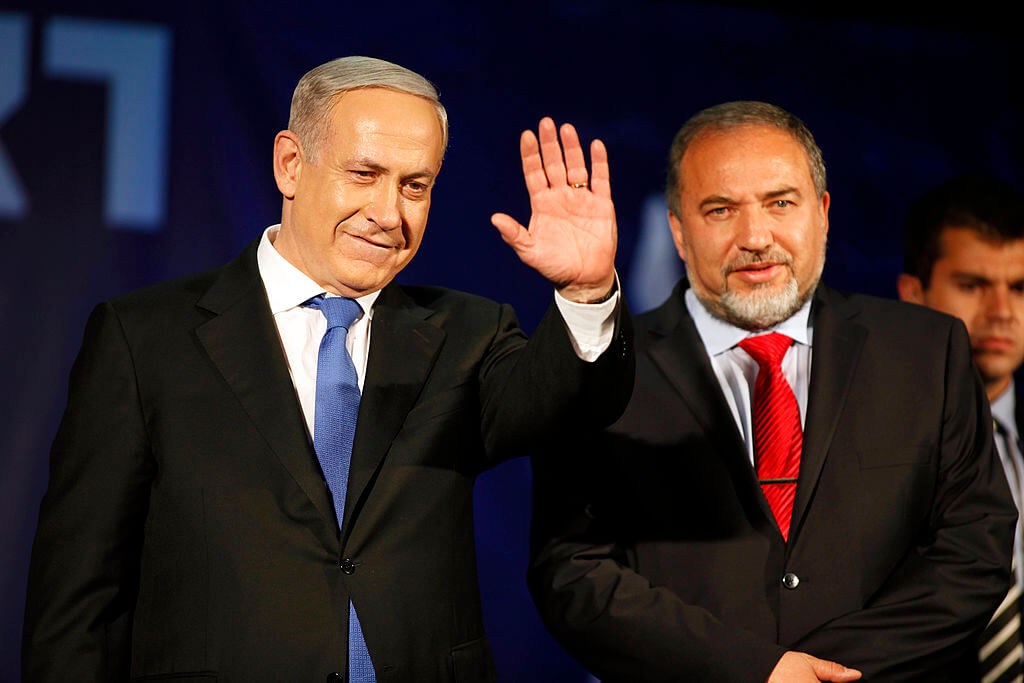 Israeli Prime Minister Benjamin Netanyahu waves to supporters with former Israeli Minister for Foreign Affairs Avigdor Liberman in 2013.