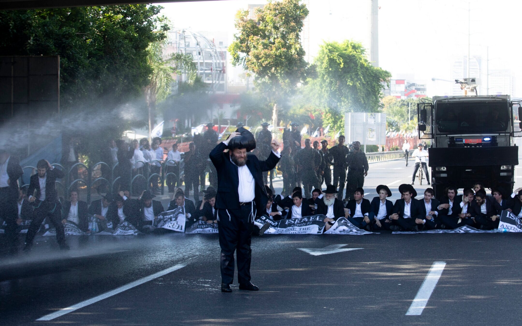 Police officers use water cannons as haredi Orthodox Jewish men block a main highway during a protest against drafting into the Israeli army on June 2, 2024 in Bnei Brak, Israel. (Amir Levy/Getty Images)