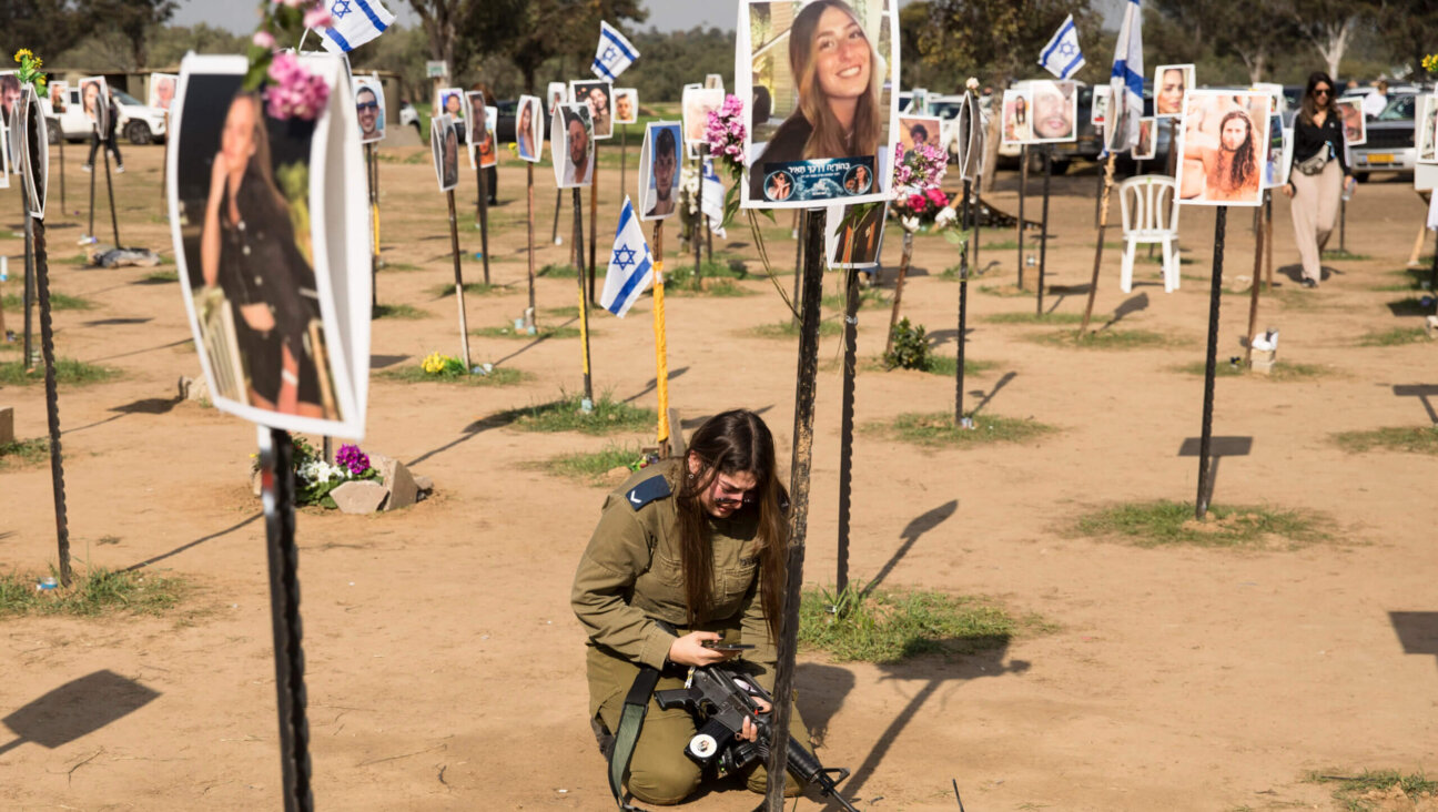 A soldier mourns near a photo of a deceased relative at the Nova music festival site on January 5, 2024, in Re'im, Israel. 