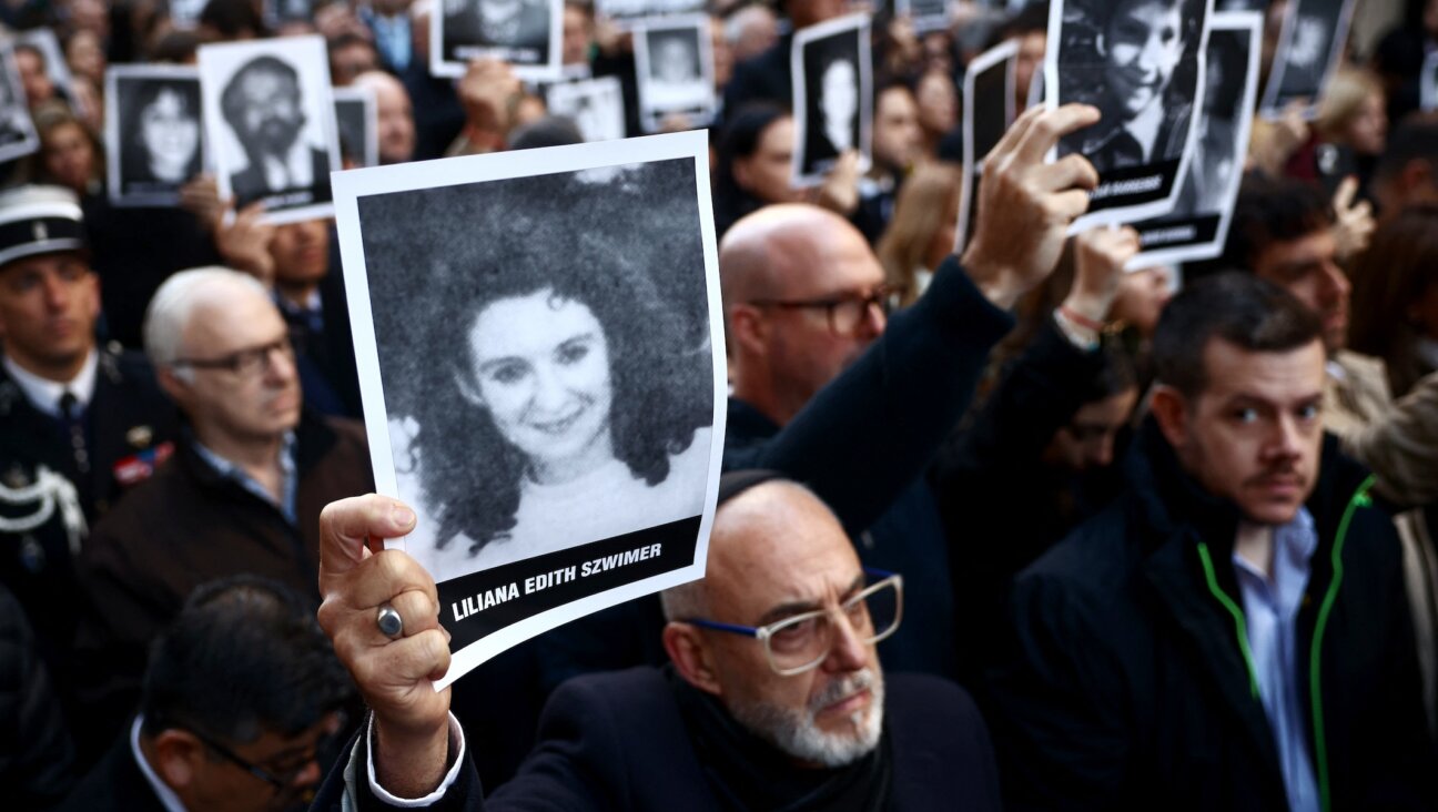 People hold pictures of victims during a ceremony to commemorate the anniversary the 1994 AMIA Jewish center bombing attack, Buenos Aires, July 18, 2024. 