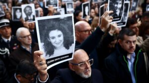 People hold pictures of victims during a ceremony to commemorate the anniversary the 1994 AMIA Jewish center bombing attack, Buenos Aires, July 18, 2024. 